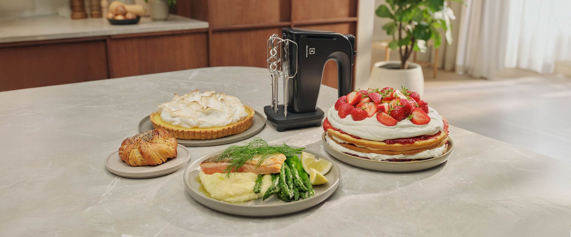 Erilaisia ruokalajeja, kuten mansikkakakku ja marenki, joka on vatkattu sähkövatkaimella.